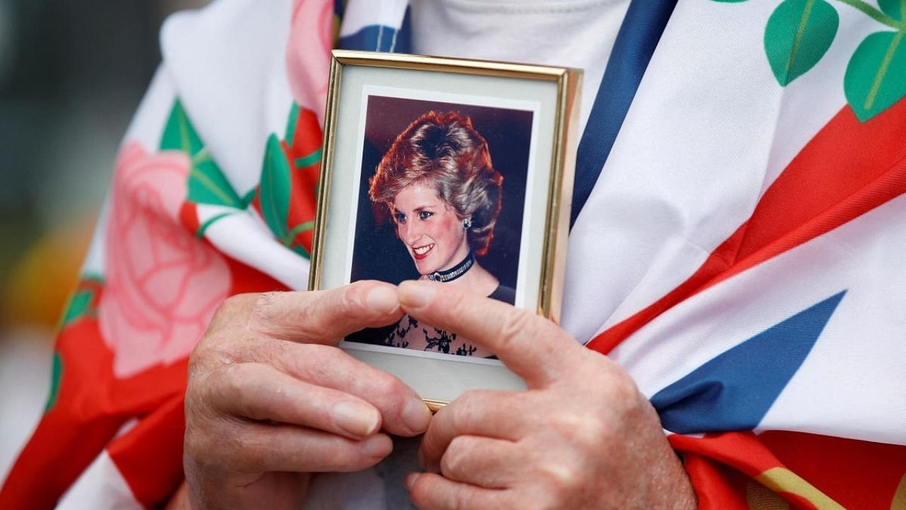 Royal fan John Loughrey holds a picture of Princess Diana as he pays tribute to her, on the 25th anniversary of her death, outside Kensington Palace, in London. Credit: Reuters photo