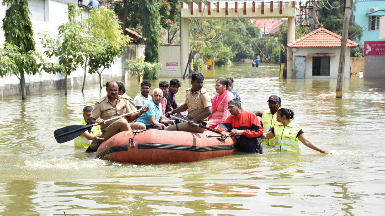Residents being rescued in inflatable boats on Sarjapur main road in Bengaluru on Tuesday. Credit: DH Photo/B K Janardhan