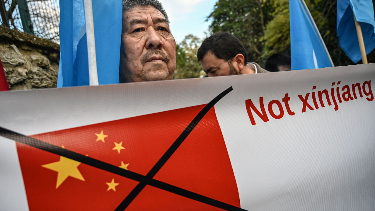 A Muslim Uyghur holds a banner as he waves a flag of East Turkestan on December 13, 2019 during a demonstration in front of China Consulate in Istanbul. Credit: AFP File Photo