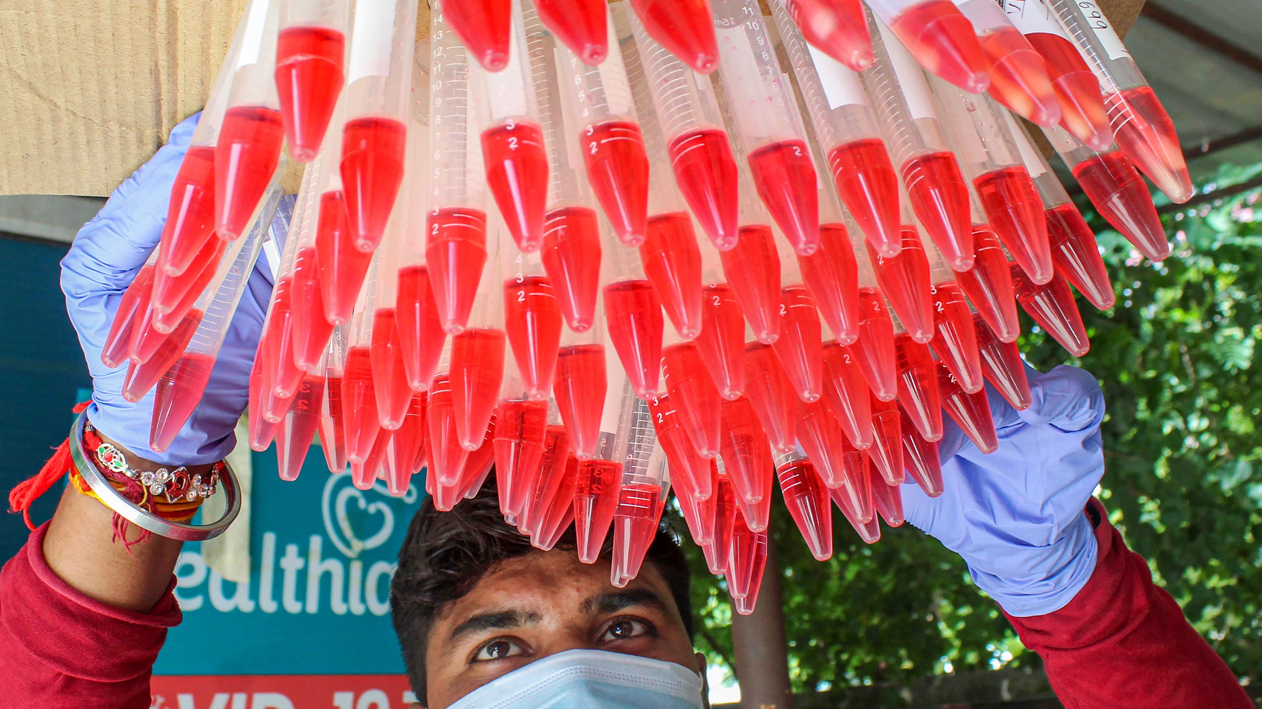 A healthcare worker with swab samples collected from people for Covid-19 testing. Credit: PTI File Photo