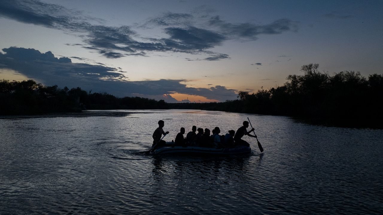 Smugglers use a raft to transport migrants from Mexico across the Rio Grande river into the United States, in Roma, Texas, US. Credit: Reuters Photo