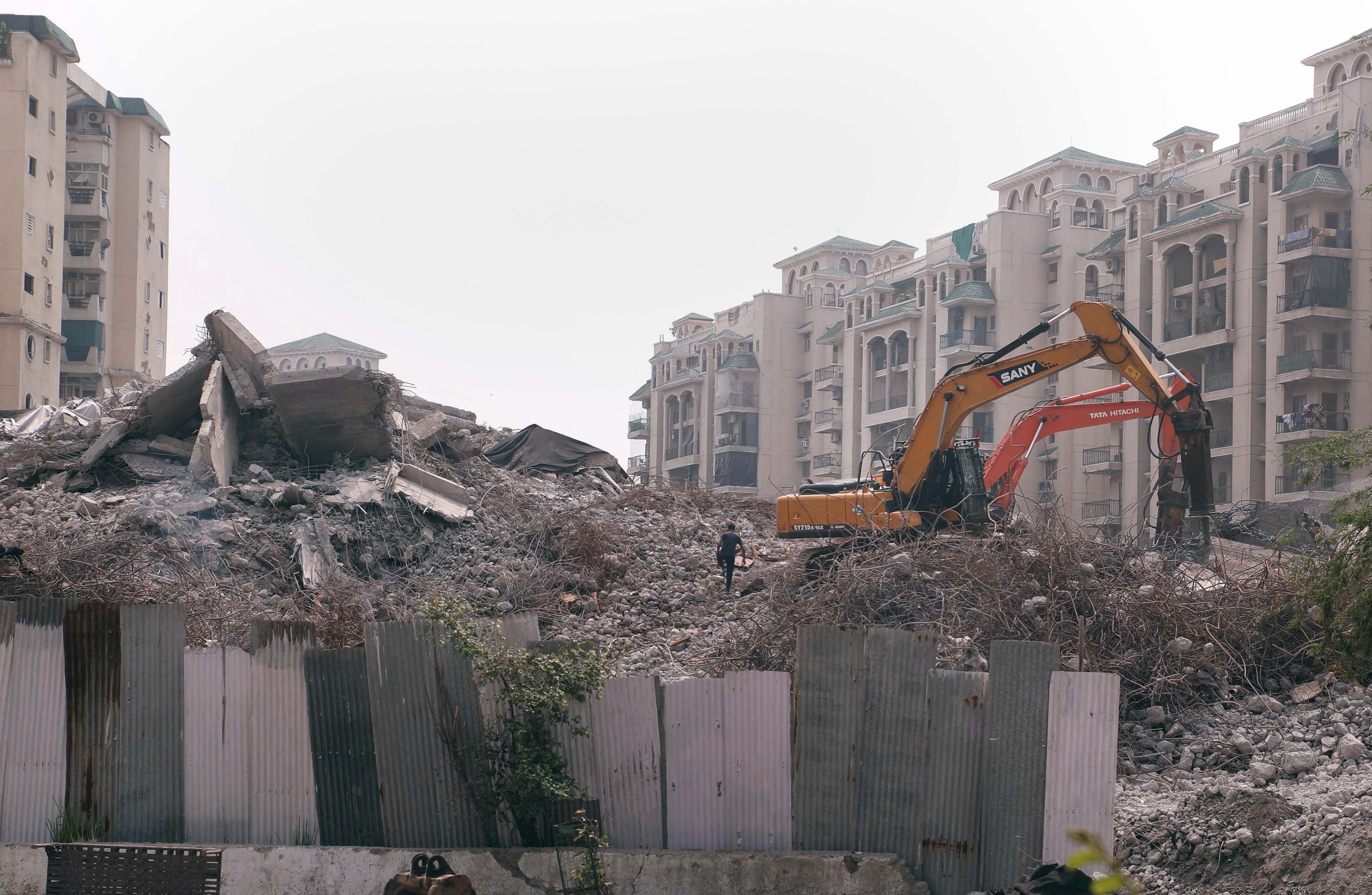 Debris clearance work underway at the site of the demolished twin towers of Supertech. Credit: PTI Photo