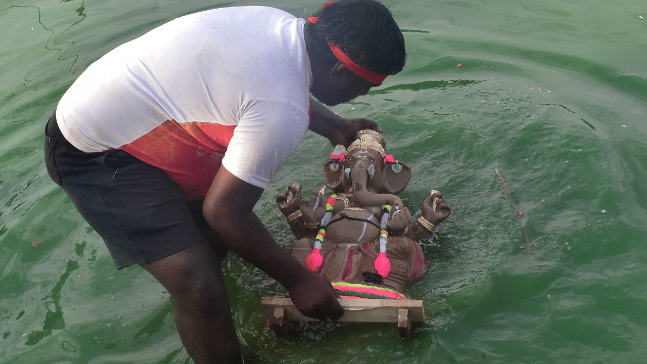 People immerse Ganesha idols at Halasuru Lake in Bengaluru on Friday. Credit: DH Photo