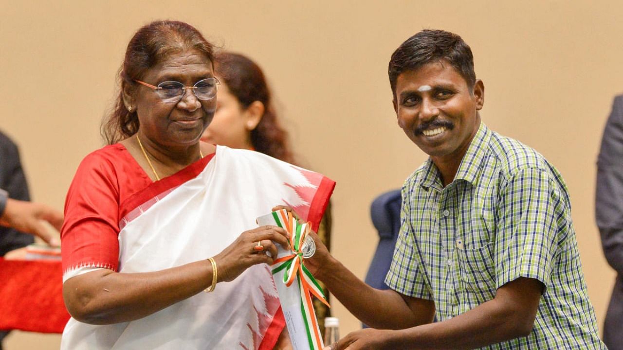 President Droupadi Murmu presents an award to a teacher at a function on Teachers' Day at Vigyan Bhavan, in New Delhi. Credit: PTI Photo