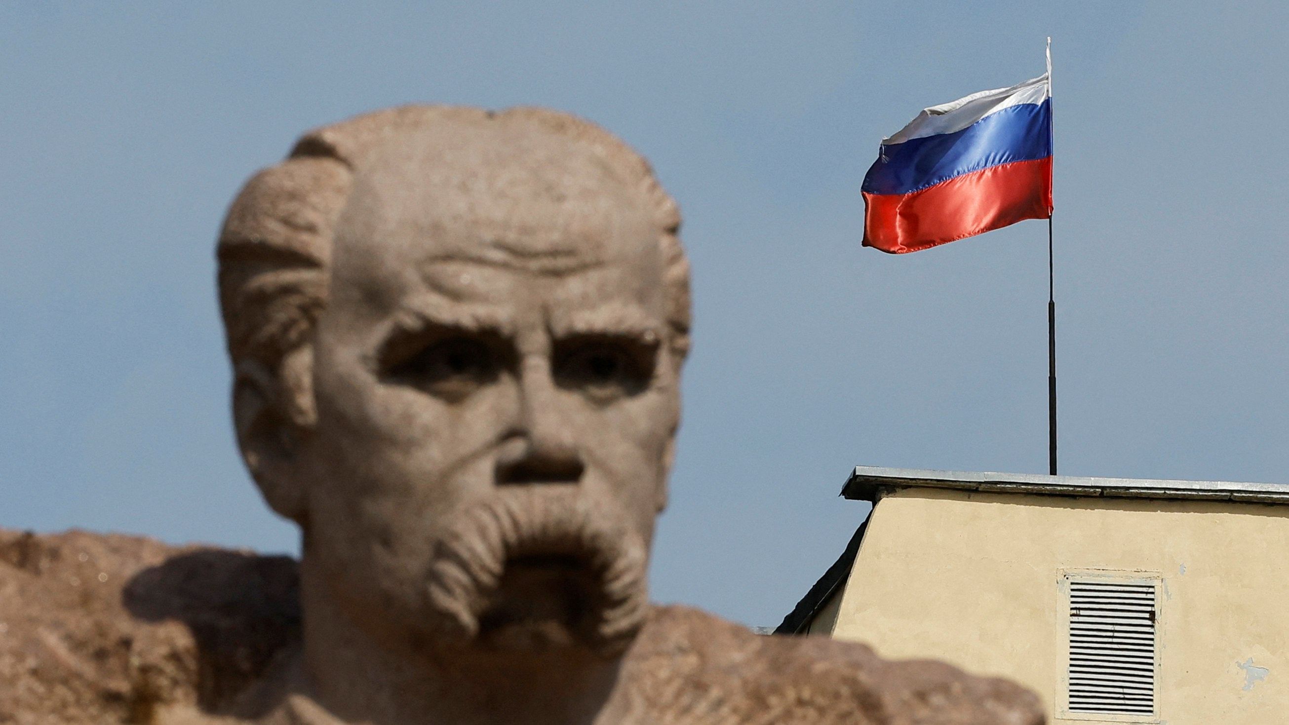The Russian flag flies on the top of a building, as a monument to Ukrainian poet Taras Shevchenko is seen in the foreground, in the course of Ukraine-Russia conflict in the Russian-controlled city of Enerhodar in Zaporizhzhia region, Ukraine. Credit: Reuters Photo