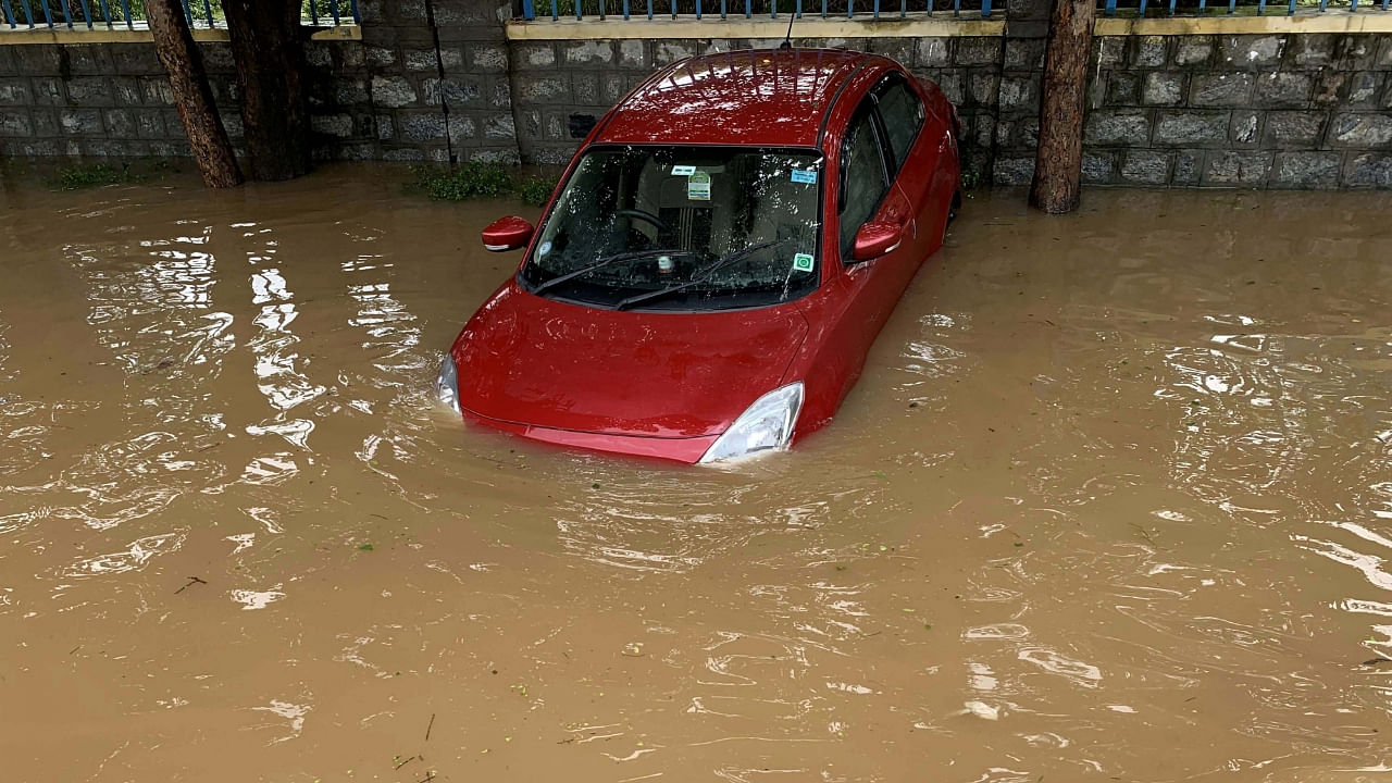 A partially submerged car on a waterlogged street after heavy monsoon rains, Bengaluru. Credit: IANS photo