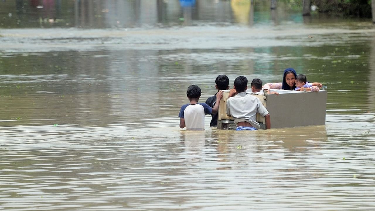 Residents wade through floodwaters in Bellandur. Credit: DH Photo