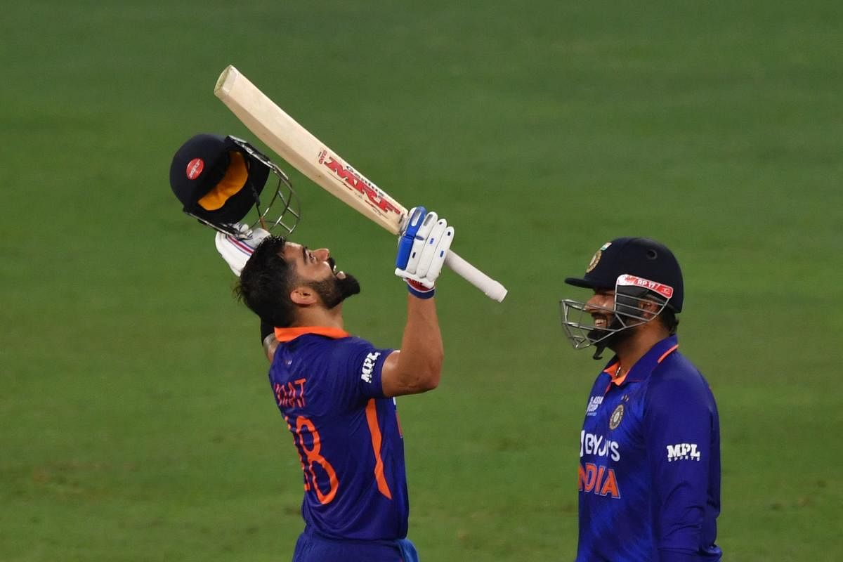  India's Virat Kohli (L) celebrates after scoring a century (100 runs) as his teammate Rishabh Pant smiles during the Asia Cup Twenty20 international cricket Super Four match between Afghanistan and India at the Dubai International Cricket Stadium in Dubai on September 8, 2022. Credit: AFP Photo