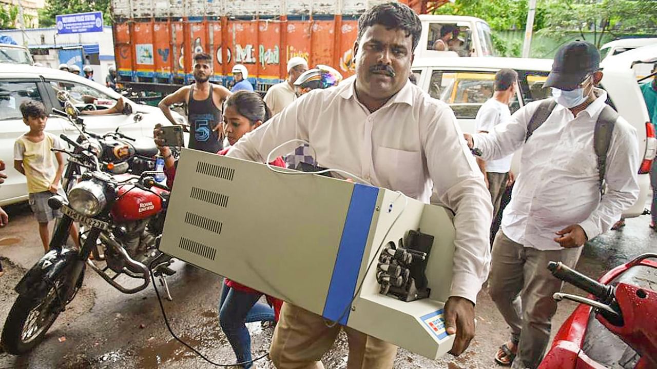 An official carries a cash counting machine during a raid in Kolkata. Credit: PTI Photo