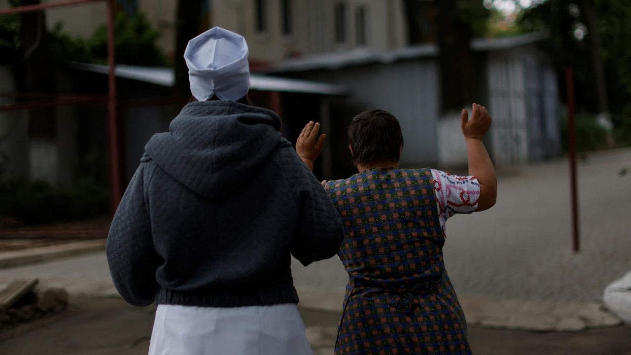 Nurse Ekaterina Masiuk, 57, leads a resident to a basement shelter at a facility for people with special needs, amid Russia's invasion of Ukraine, in Odesa. Credit: Reuters photo