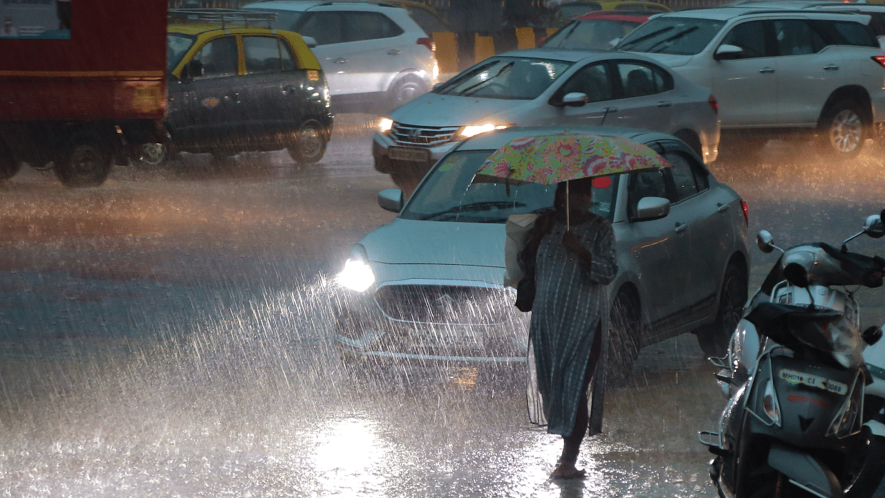 Commuters on a road during heavy monsoon rains, at Fort area in Mumbai. Credit: PTI Photo