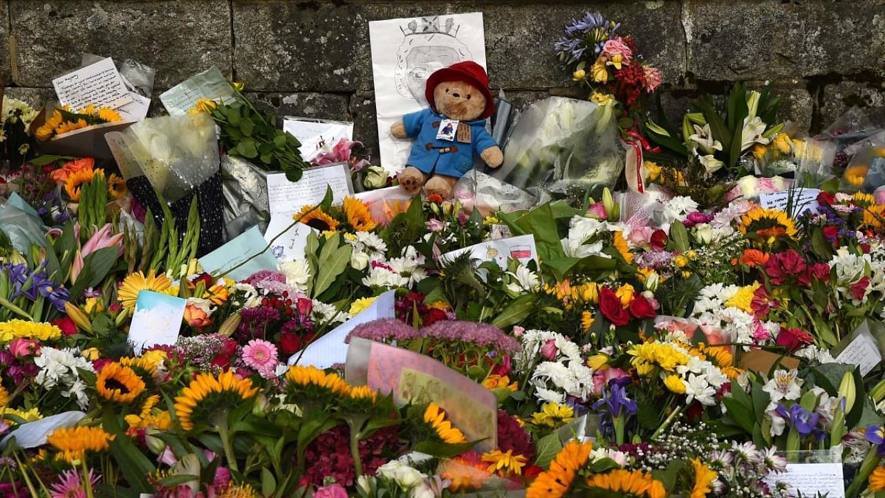 A Paddington teddy bear sits amongst flowers outside the Balmoral Castle in Ballater. Credit: AFP Photo