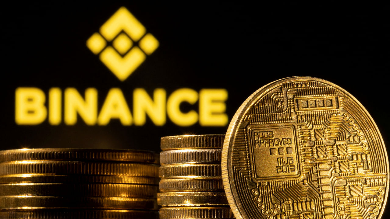 A representation of cryptocurrency is seen in front of Binance logo. Credit: Reuters File Photo