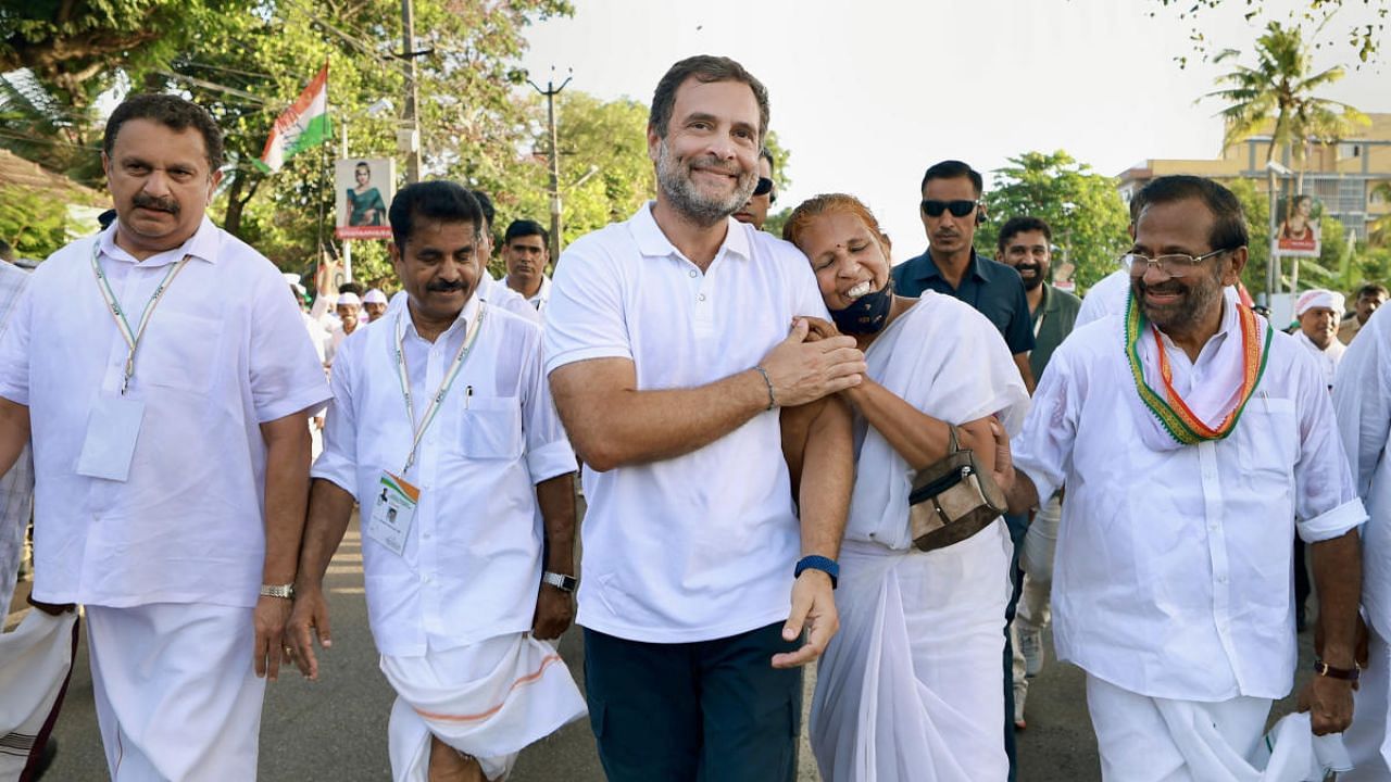 Congress leader Rahul Gandhi walks with an elderly supporter during the party's 'Bharat Jodo Yatra', in Thiruvananthapuram district. Credit: PTI Photo