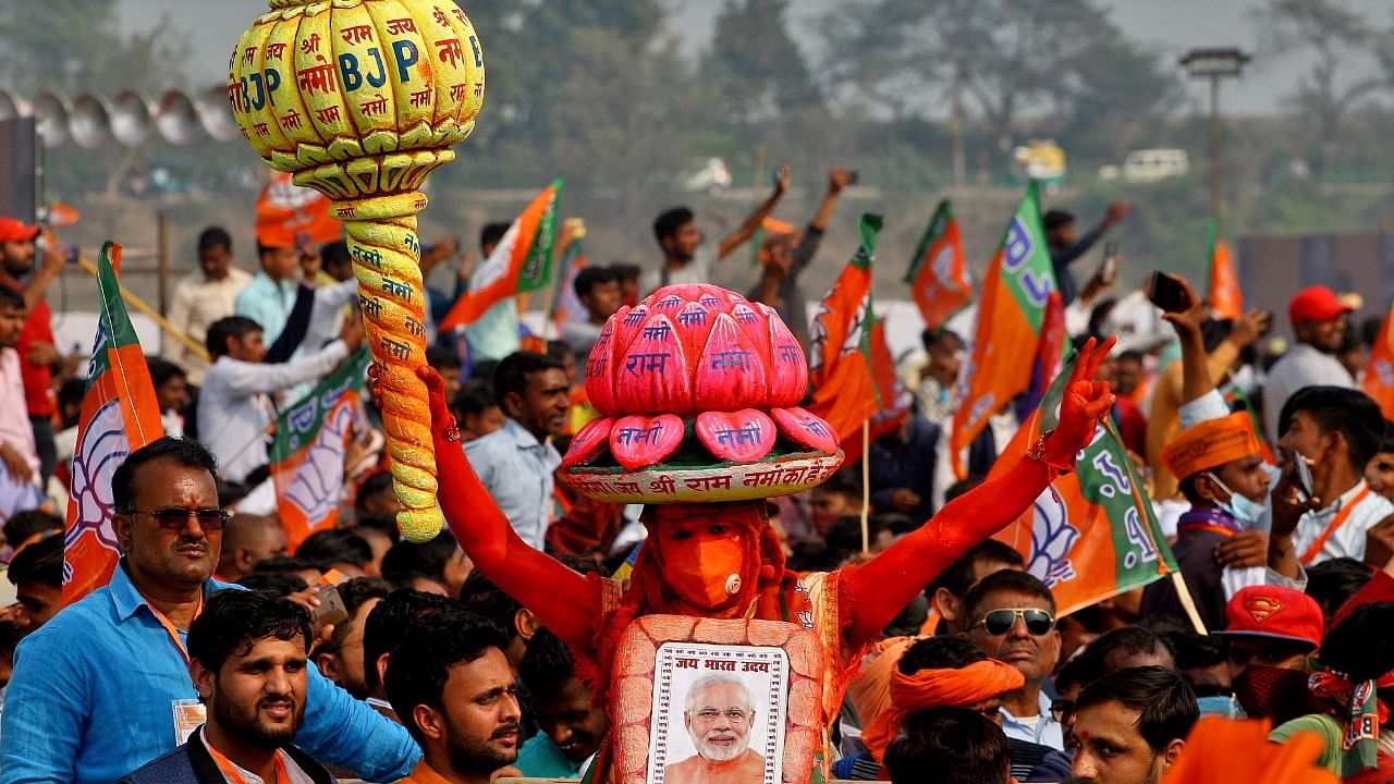 Supporters of BJP carry chairs as they arrive to attend a rally being addressed by PM Modi. Credit: Reuters Photo