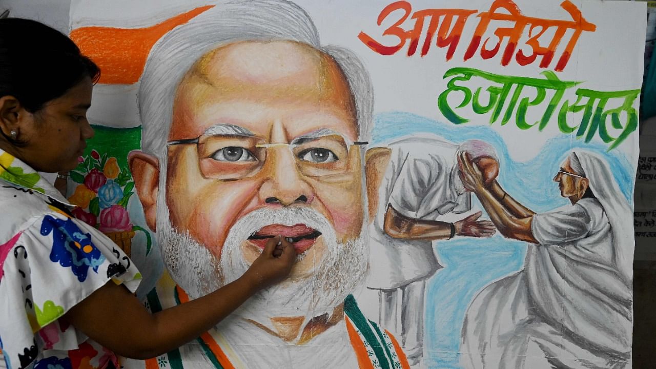An art school student gives final touches to paintings of Indian Prime Minister Narendra Modi on the eve of his birthday in Mumbai. Credit: AFP Photo