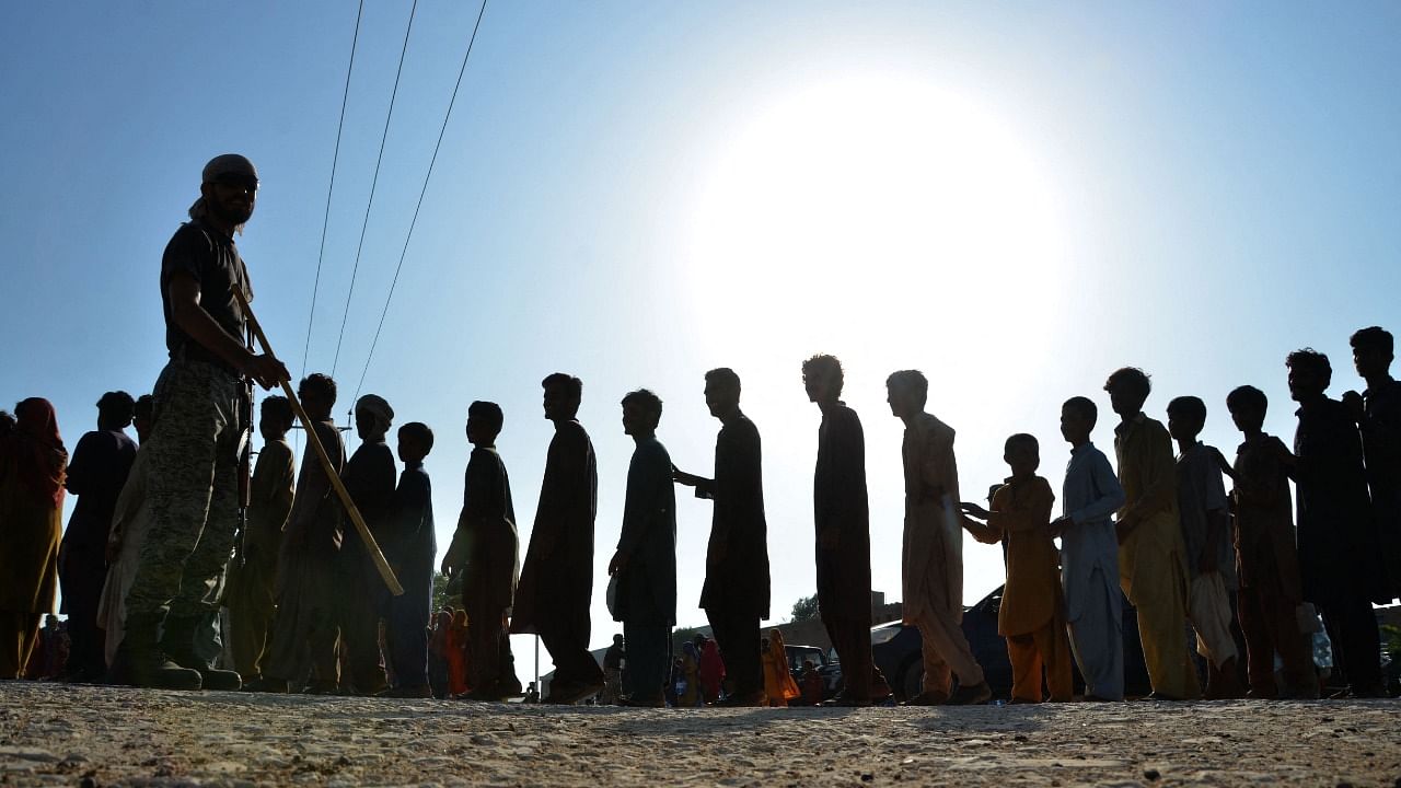 Flood-affected people queue to receive food aid distributed at Dera Allah Yar town of Jaffarabad district in Balochistan. Credit: AFP Photo