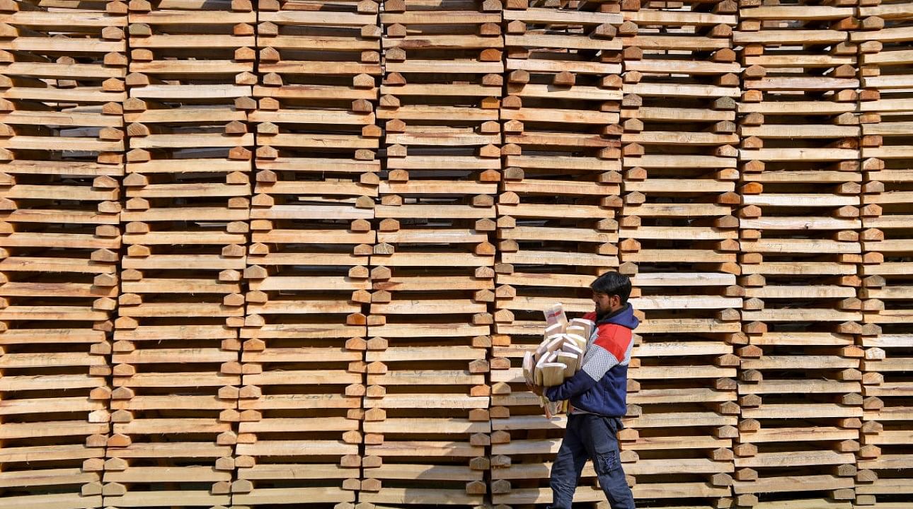 A worker walks past willow clefts which are used for manufacturing of cricket bats, in a factory in Anantnag district of south Kashmir. Credit: PTI File Photo