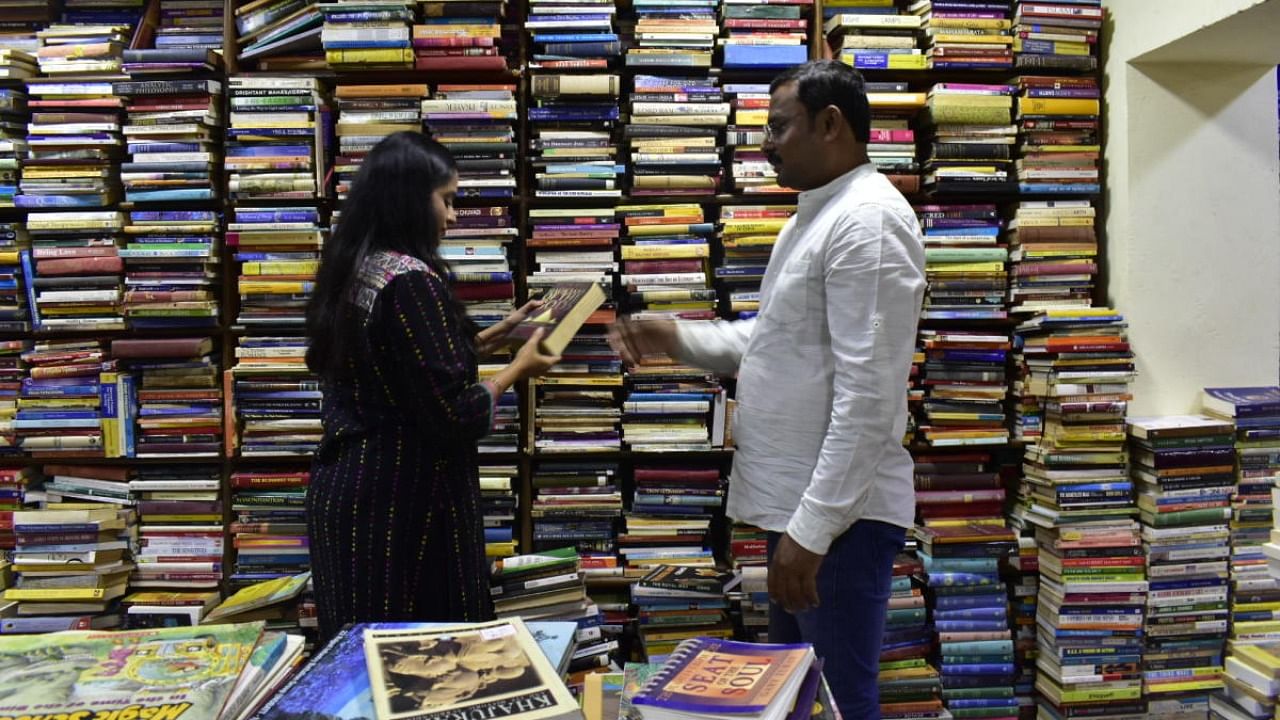 The reporter (left) at The Bookworm with its owner Krishna Gowda. Credit: DH Photo