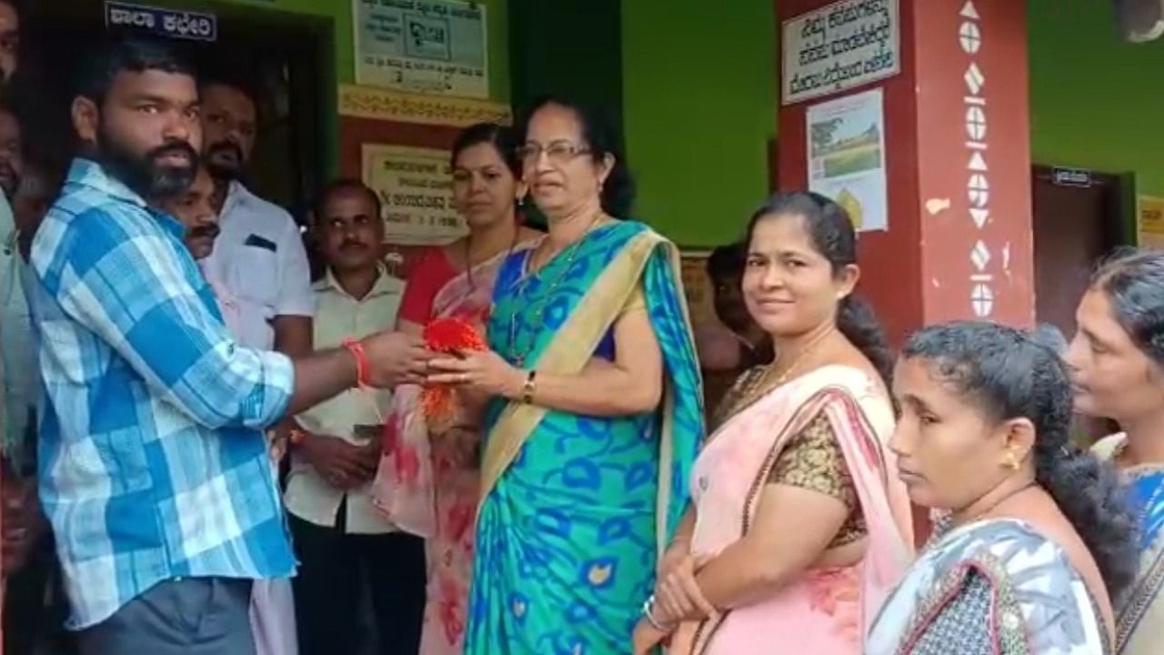 Parents hand over rakhis to teacher to be tied to the wrist of the children at Government Higher Primary School in Papemajalu. Credit: DH Photo