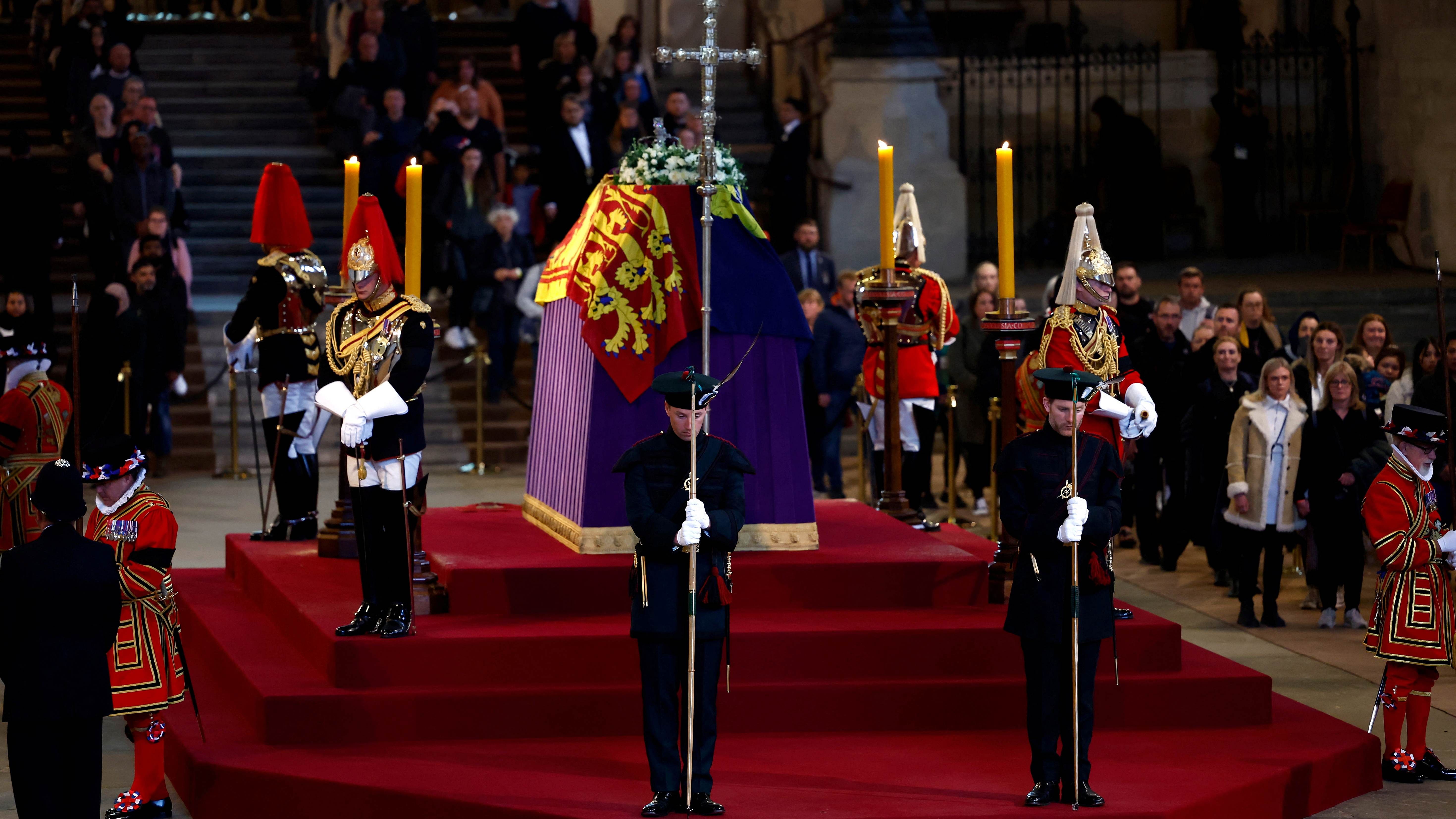 Members of the public pay their respects as they pass Queen Elizabeth II's flag-draped coffin. Credit: Reuters Photo