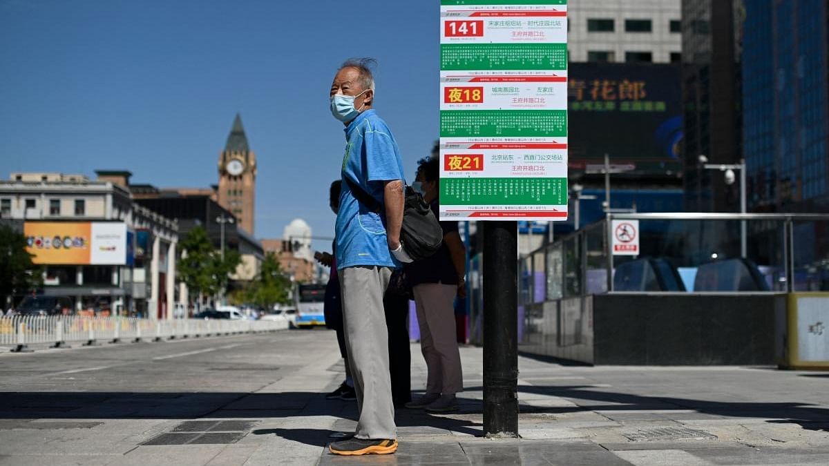 An elderly man stands at a bus stop in Beijing. Credit: AFP Photo