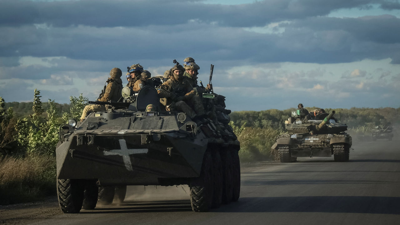 Ukrainian servicemen ride on Armoured Personnel Carrier (APC) and a tank near Izium, September 19, 2022. Credit: Reuters Photo