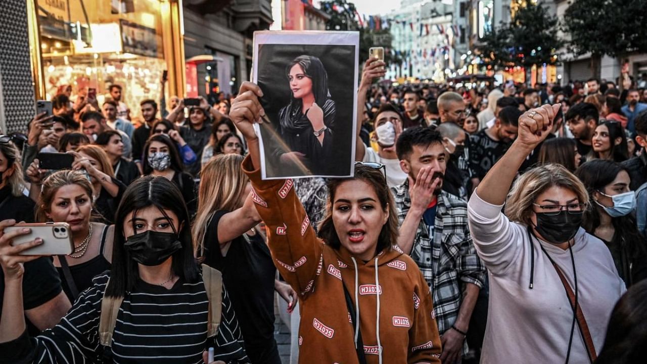 A protester holds a portrait of Mahsa Amini during a demonstration in support of Amini, a young Iranian woman who died after being arrested in Tehran by the Islamic Republic's morality police, on Istiklal avenue in Istanbul on September 20, 2022. Credit: AFP Photo