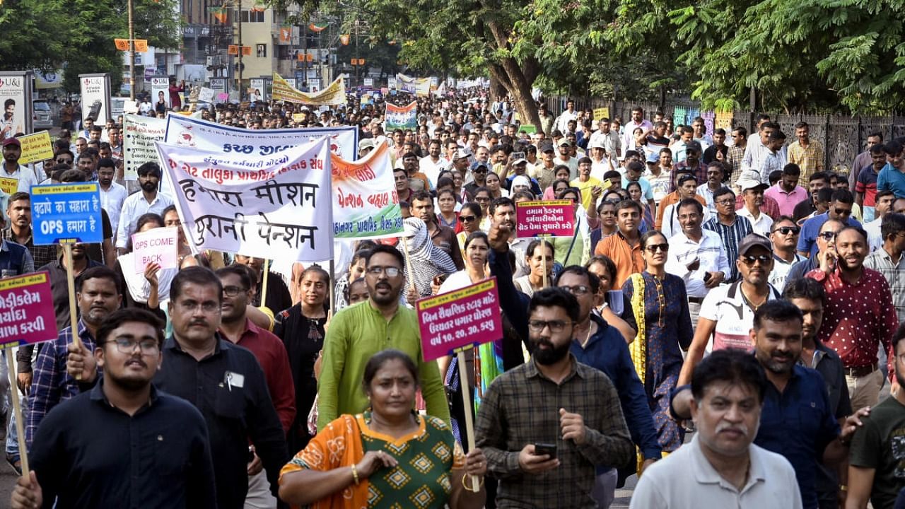 Government employees under the banners of Gujarat State Employees Mahamandal and Gujarat State United Employees Front participate in a protest march over various demands including restoration of the old pension scheme, in Rajkot, Sunday, Sept. 11, 2022. Credit: PTI Photo