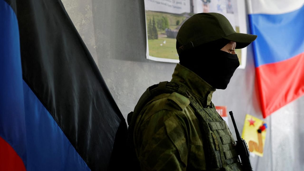 A service member of the self-proclaimed Donetsk People's Republic stands guard at a polling station ahead of the planned referendum in Donetsk. Credit: Reuters Photo
