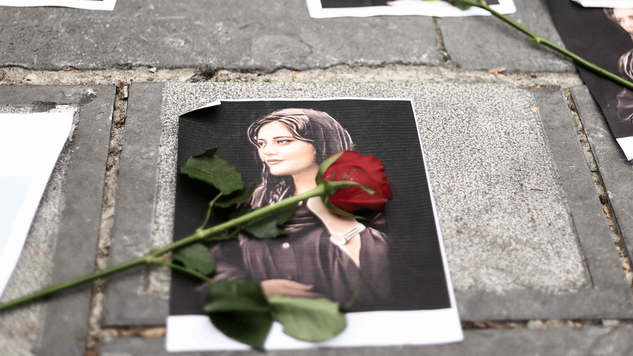 Flowers are seen on a portrait of Mahsa Amini during a demonstration in her support in front of the Iranian embassy in Brussels. Credit: AFP Photo