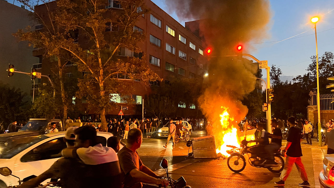  A police motorcycle burns during a protest over the death of Mahsa Amini, a woman who died after being arrested by the Islamic republic's "morality police", in Tehran, Iran September 19, 2022. Credit: Reuters via West Asia News Agency