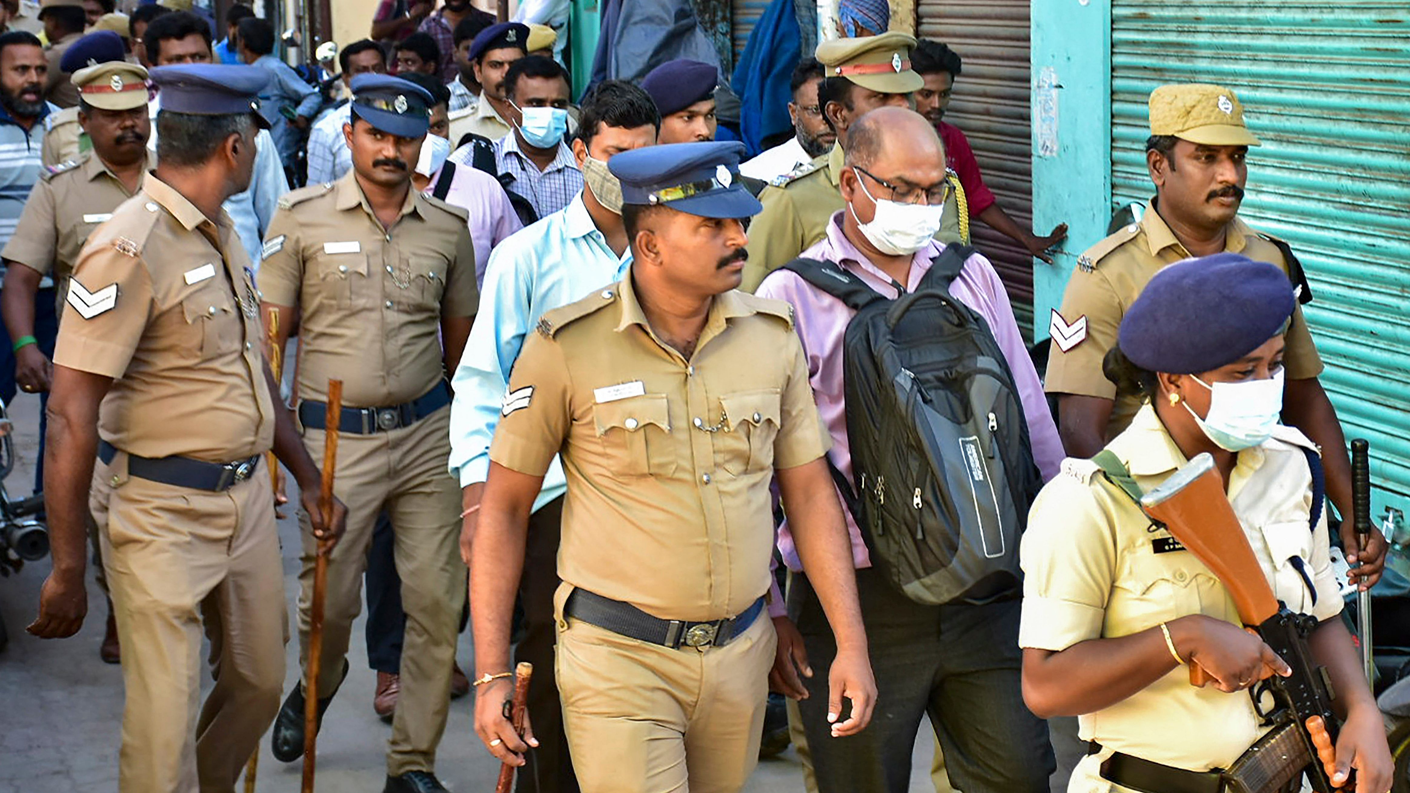 Officers of National Investigation Agency (NIA) with police personnel during a raid at the residence of a functionary of Popular Front of India (PFI), in Madurai. Credit: PTI Photo