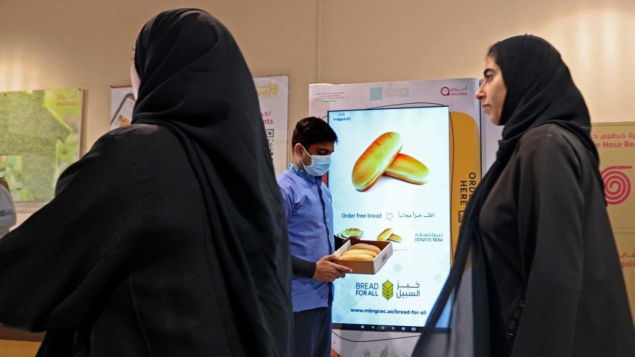 A man holds a box he collected from a vending machine which gives out free bread, in Dubai. Credit: AFP Photo