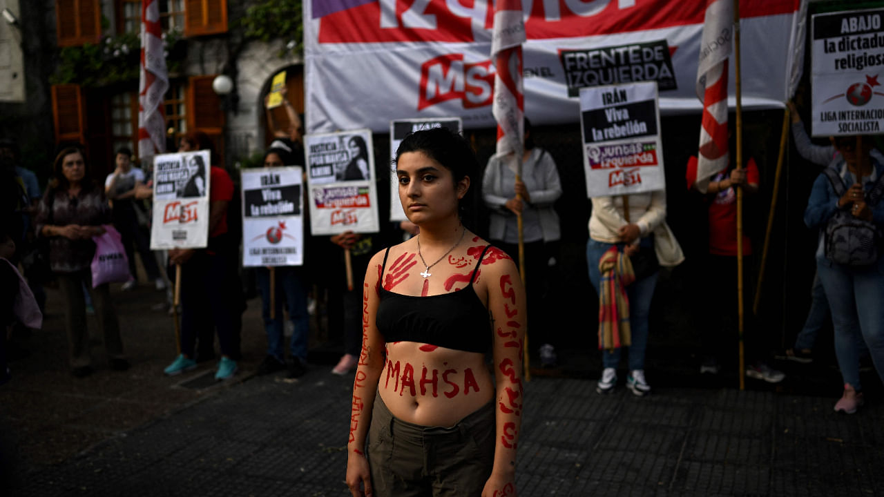 An activists bears the name Mahsa painted on her body during a demonstration over her death, outside the Iranian embassy in Buenos Aires, Argentina. Credit: AFP Photo