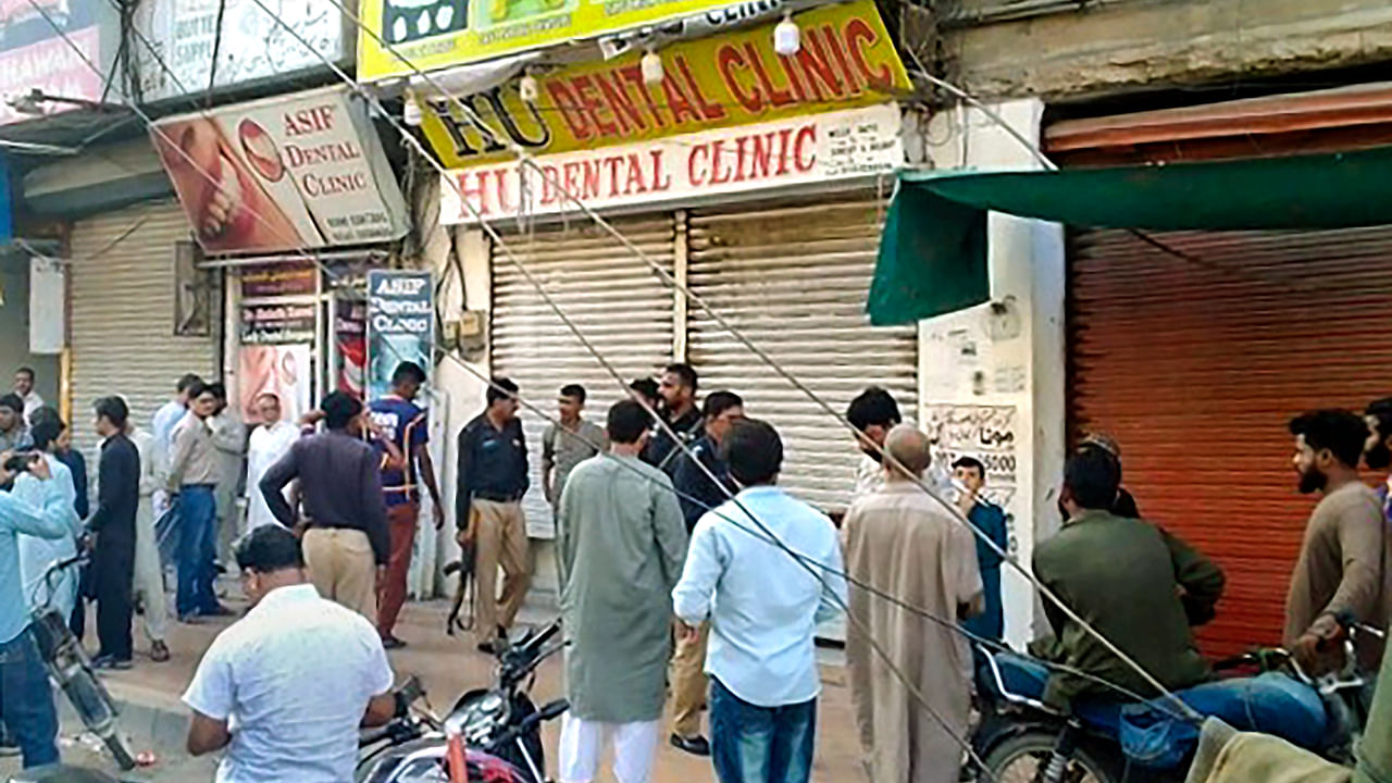 Locals gather at the site of the attack after unidentified gunmen opened fire inside a dental clinic in Pakistan's southern port city of Karachi, Wednesday, Sept. 28, 2022. Credit: PTI File Photo