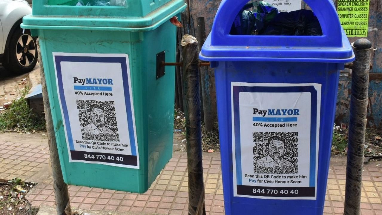 'PayMayor' posters pasted on dustbins in Hubballi on Wednesday. Credit: DH Photo