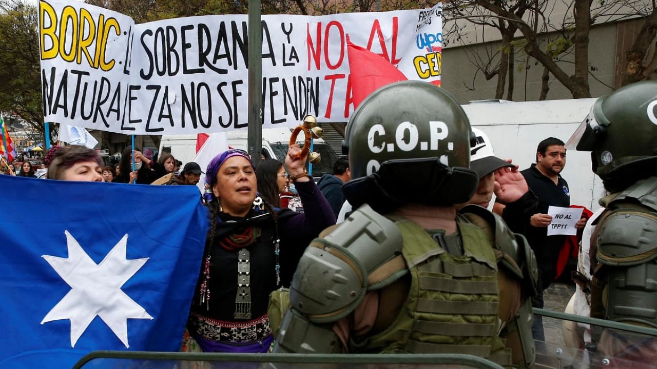 Environmental activists shout slogans in front of riot police officers during a rally to refuse the Congress approval of the Trans-Pacific Partnership (TPP), in Valparaiso, Chile September 28, 2022. Credit: Reuters Photo for representation
