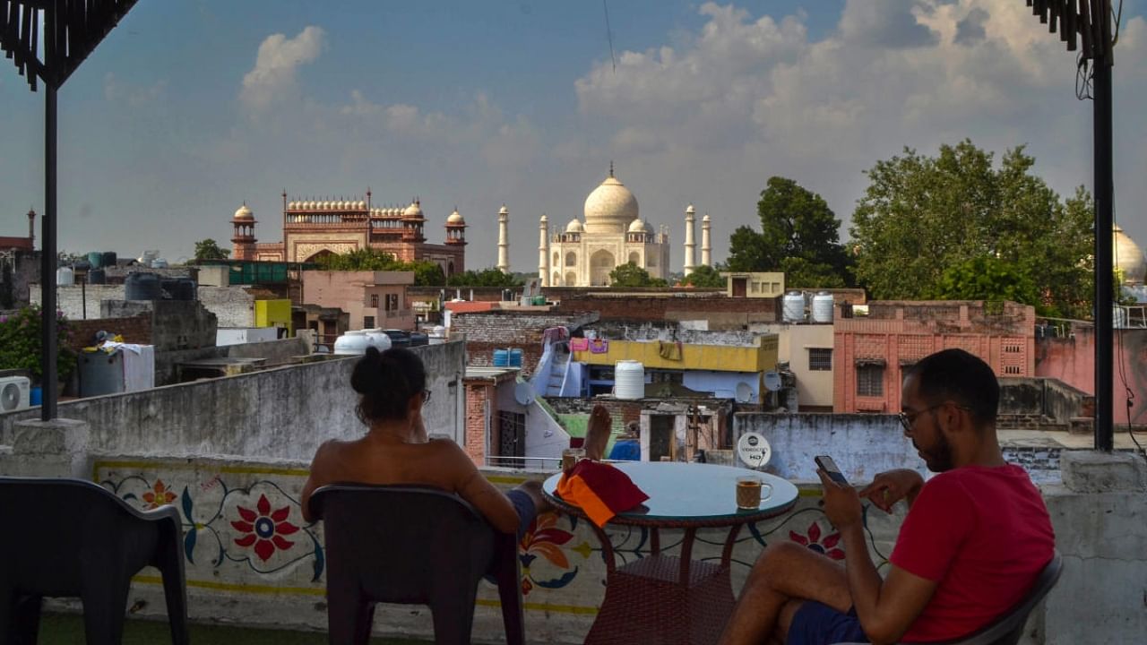 Tourists at a restaurant in the backdrop of the Taj Mahal, in Agra, Wednesday, Sept. 28, 2022. Supreme Court has directed Agra Development Authority (ADA) to stop all commercial activities within a 500-metre radius of the UNESCO World Heritage Site. Credit: PTI Photo