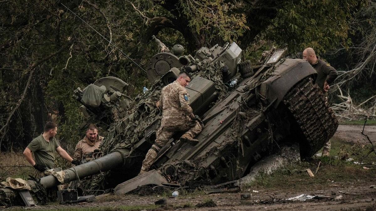 Ukrainian soldiers scavenge an abandoned Russian T-90A tank in Kyrylivka, in the recently retaken area near Kharkiv. Credit: AFP Photo