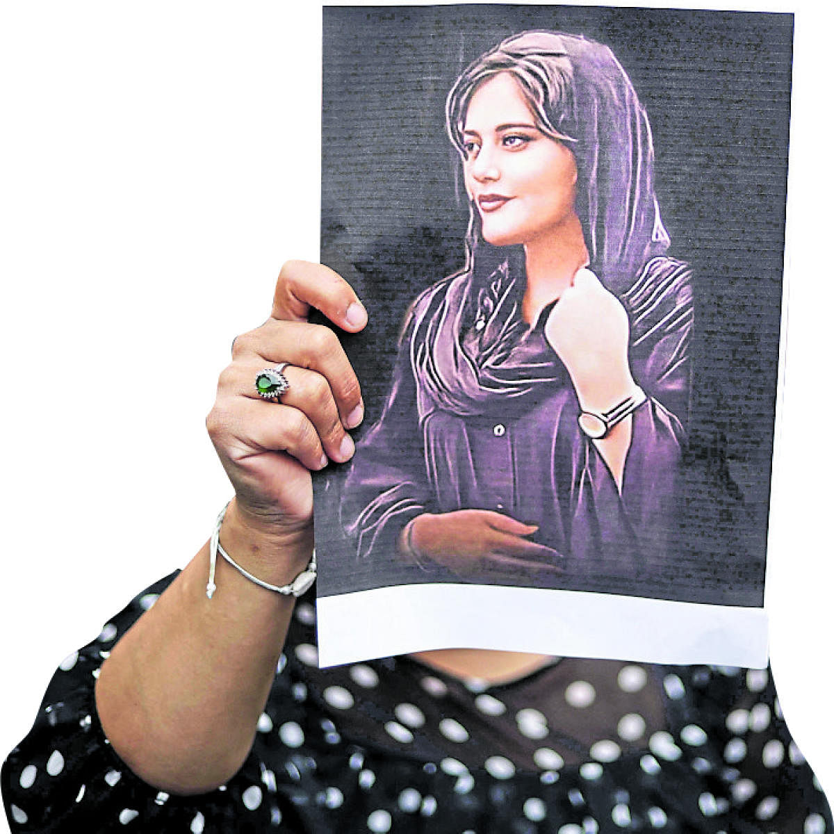 A protester holds a portrait of Mahsa Amini during a demonstration in her support in front of the Iranian embassy in Brussels. (AFP)