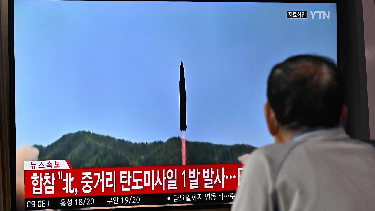 A man watches a television screen showing a news broadcast with file footage of a North Korean missile test, at a railway station in Seoul on October 4, 2022. Credit: AFP Photo