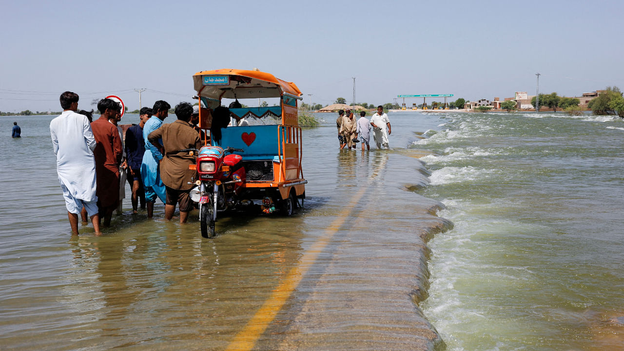 Displaced people stand on flooded highway, following rains and floods during the monsoon season in Sehwan, Pakistan, September 16, 2022. Credit: Reuters File Photo