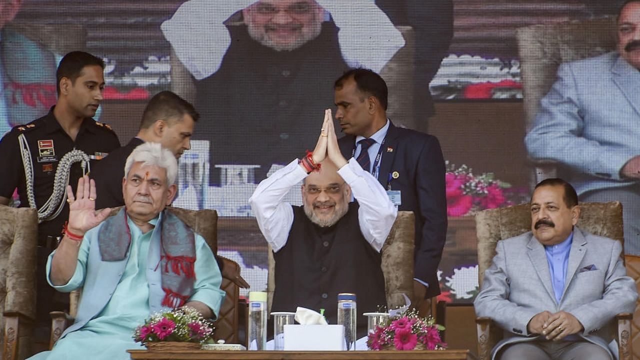 Union Home Minister Amit Shah, with J & K Lt Governor Manoj Sinha and MoS Jitendra Singh, greets the crowd during a public rally at the Showkat Ali Stadium in Baramulla district of north Kashmir, Wednesday, Oct. 5, 2022. Credit: PTI Photo