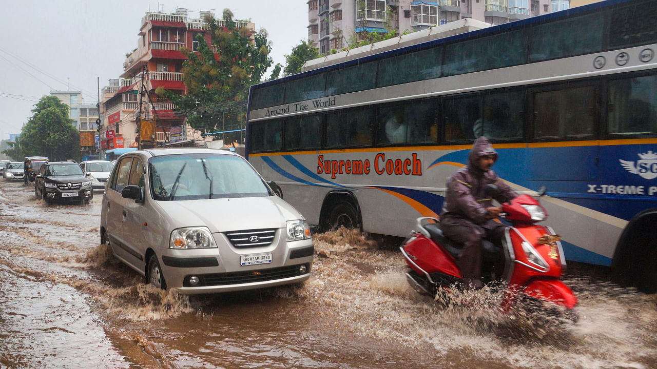 Commuters wade through a waterlogged road following rainfall, in Bhubaneswar, Tuesday, Oct. 4, 2022. Credit: PTI Photo