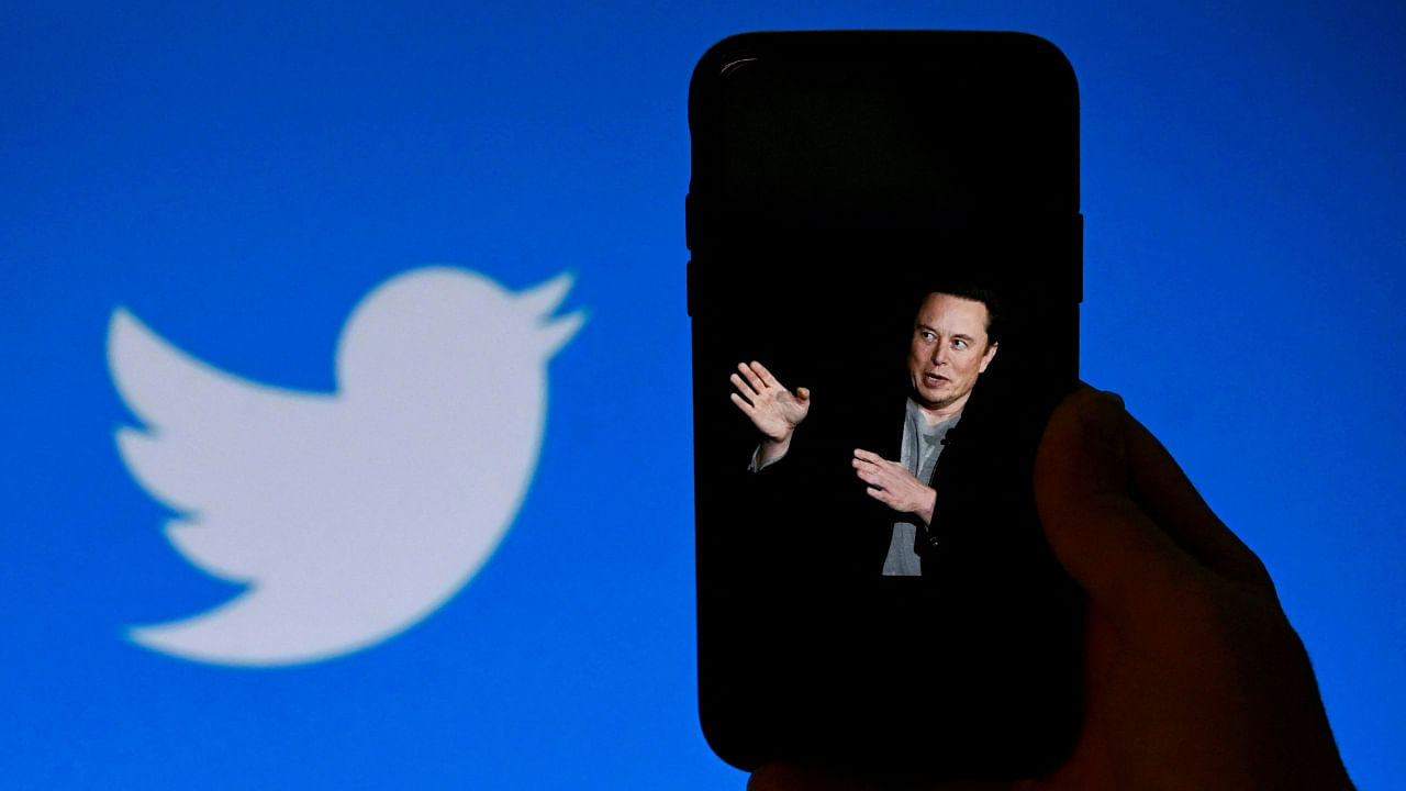 In this photo illustration, a phone screen displays a photo of Elon Musk with the Twitter logo shown in the background, on October 4, 2022, in Washington, DC. Credit: AFP Photo