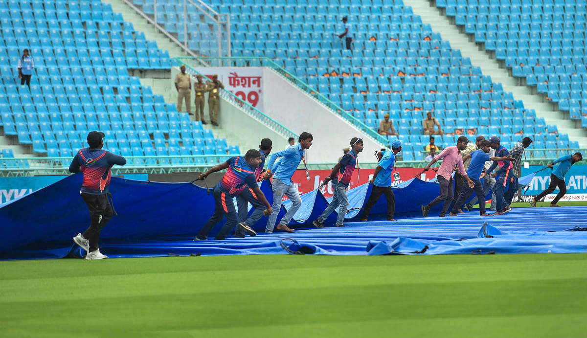 Ground staff use tarpaulin sheet to cover the field before the 1st ODI cricket match between India and South Africa, at the Bharat Ratna Shri Atal Bihari Vajpayee Ekana Cricket Stadium in Lucknow. Credit: PTI Photo