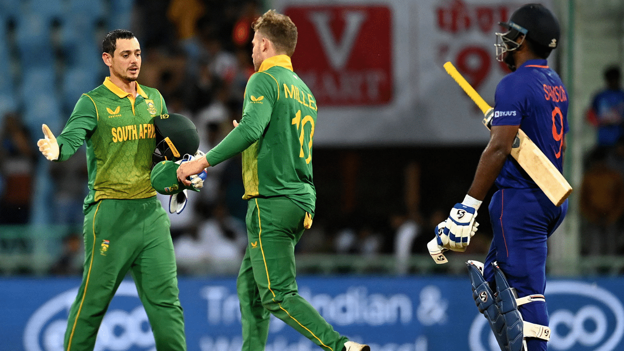South Africa's Quinton de Kock (L) and David Miller celebrate their victory as India's Sanju Samson (R) watches. Credit: AFP Photo