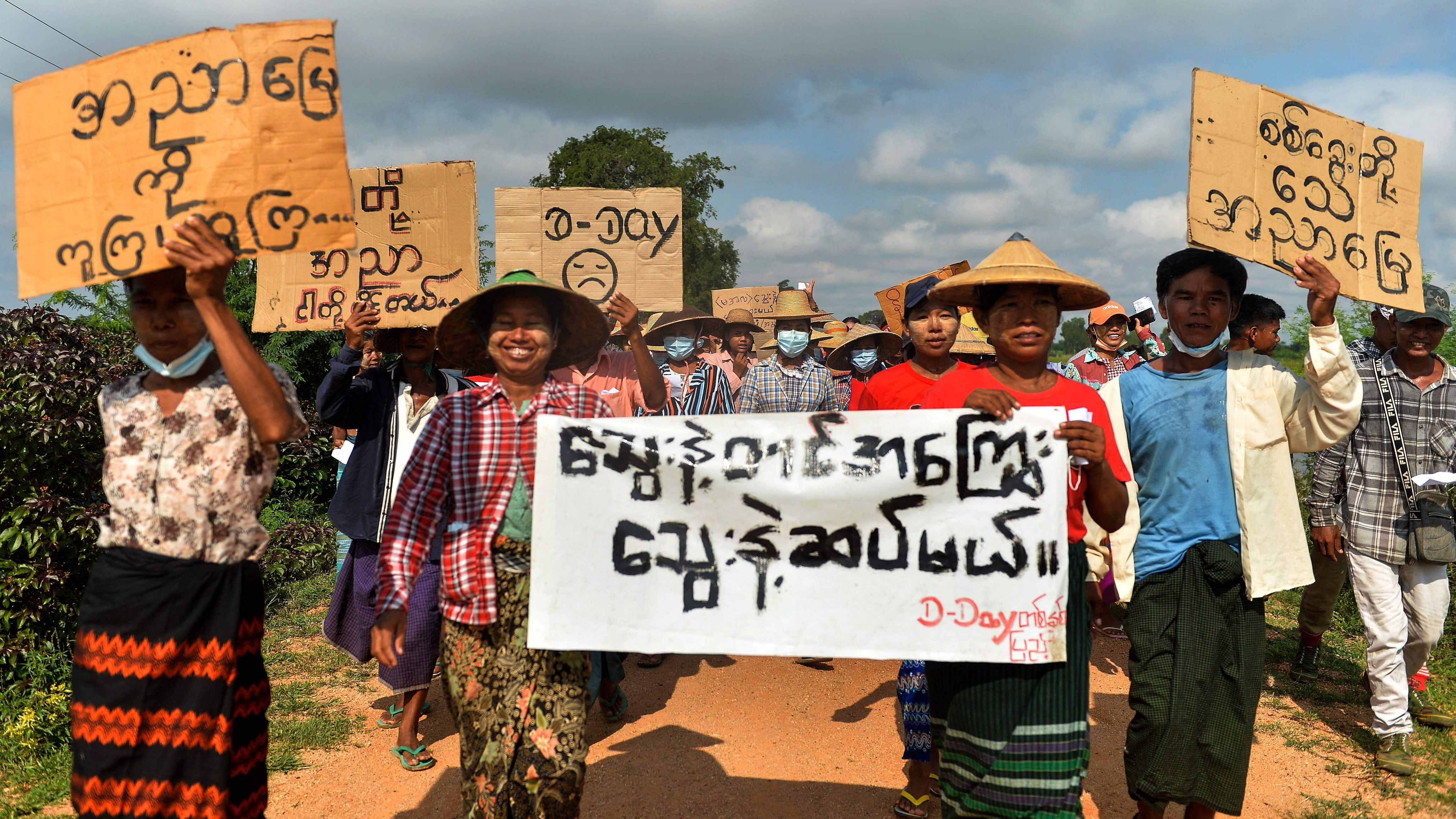 Protesters hold banners as they take part in a demonstration against the military coup. Credit: AFP Photo