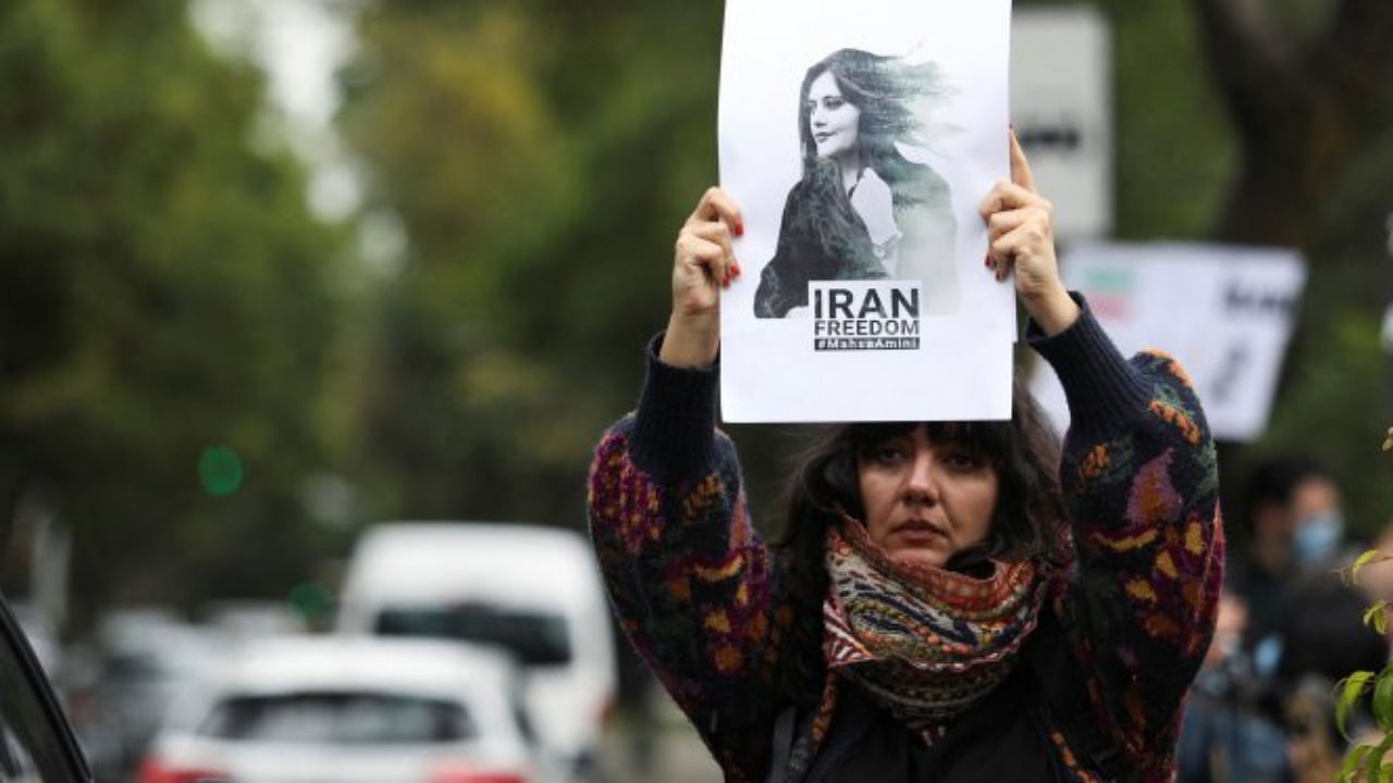 A woman holds up a sign during a protest against the Islamic regime of Iran and the death of Mahsa Amini, outside the Iranian embassy in Mexico City. Credit: Reuters Photo